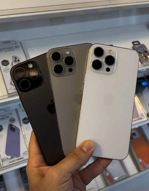 Três iPhones Pro Max preto, titânio e branco na loja Pointcell